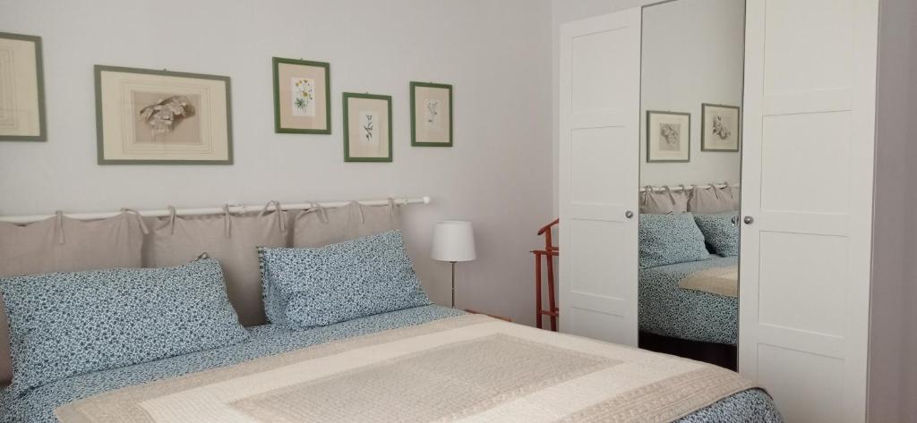 een slaapkamer met een bed met blauwe kussens en een spiegel bij Casa Bartolacci Charme in Bivigliano (Near Mugello and Florence) in Bivigliano
