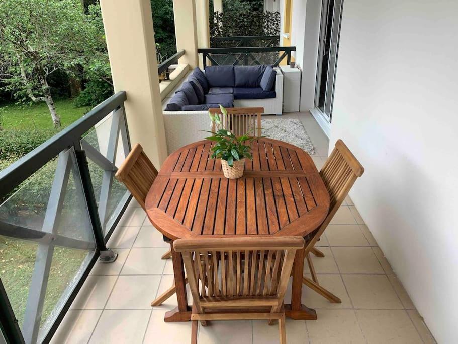 une table et des chaises en bois sur un balcon dans l'établissement Appartement T3 à Bayonne avec terrasse de 14 m2, à Bayonne