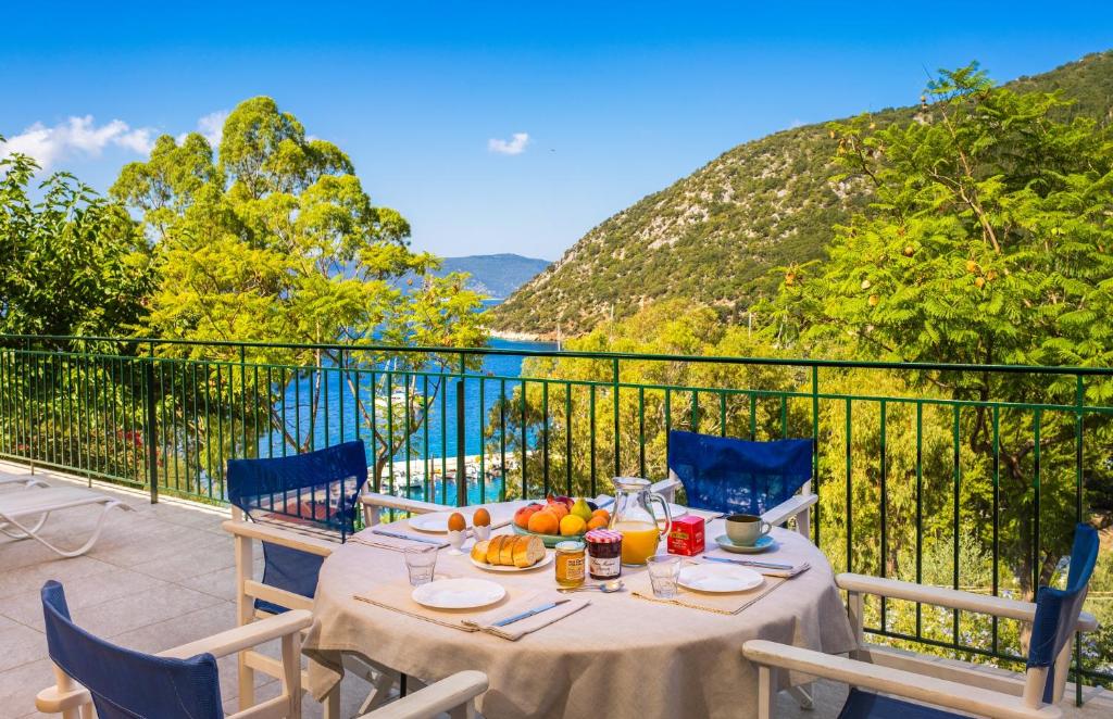 a table on a balcony with a view of the water at Lemonia Beach Villa in Stavros