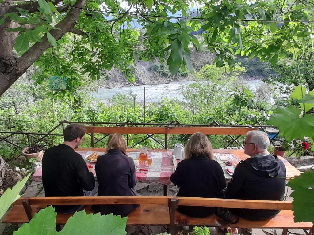 un grupo de personas sentadas en una mesa de picnic en Honey-House “Kastrioti” en Përmet