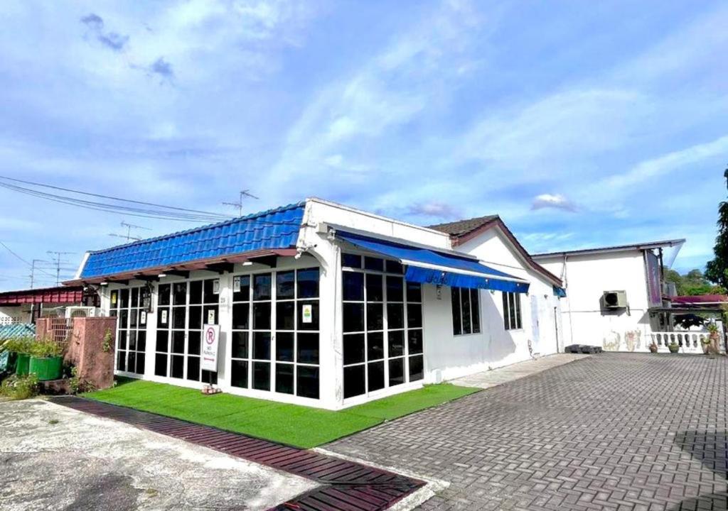 een wit gebouw met een blauw dak bij RV @ U GARDEN STAY in Skudai