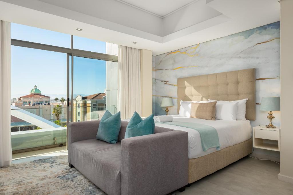 um quarto com uma cama, um sofá e uma janela em Crystal Towers 212 em Cidade do Cabo