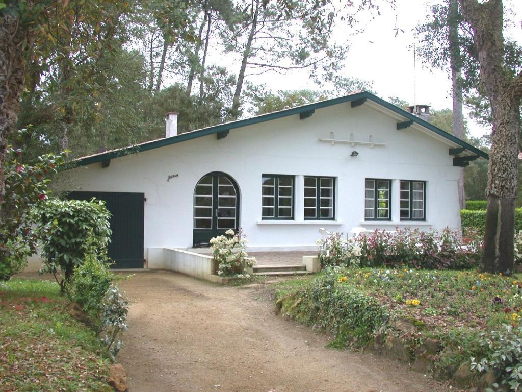 une maison blanche avec une allée devant dans l'établissement Ourika - Hossegor belle villa située proche du lac marin du centre ville et du stade, à Soorts-Hossegor