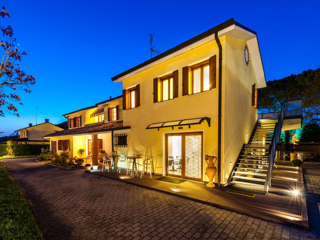 a white house with stairs leading up to it at Ca' del Faro Bibione in Bibione