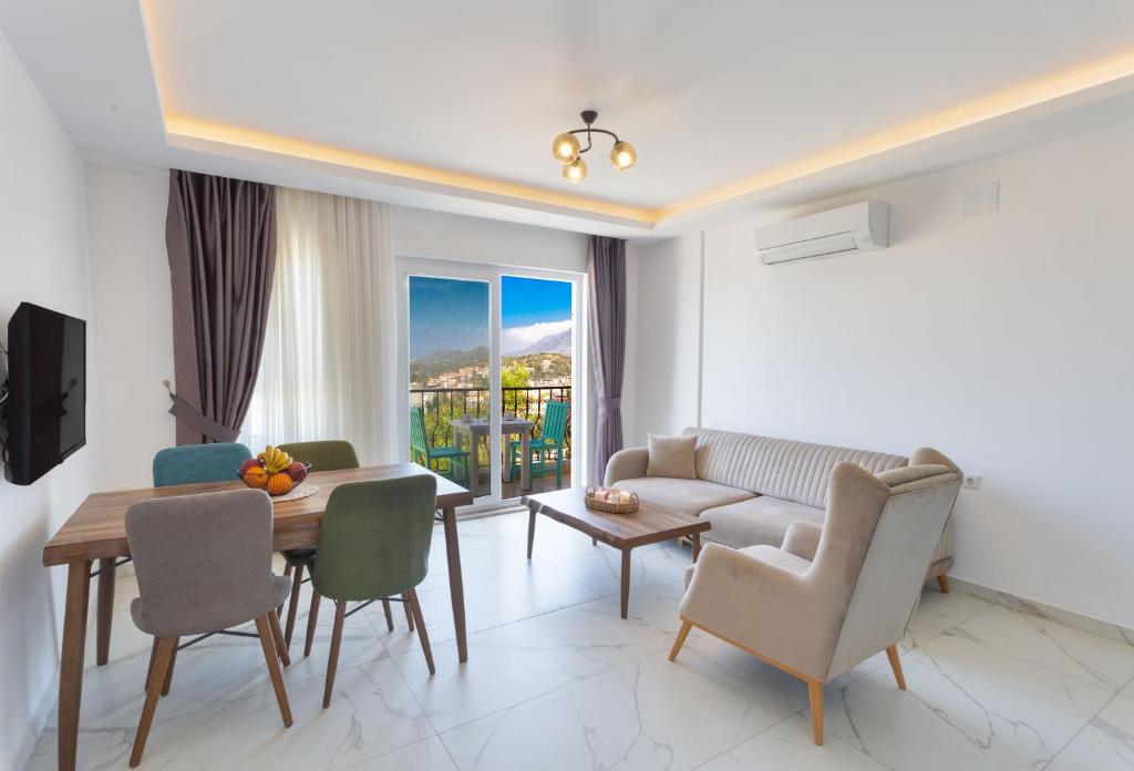 a living room with a couch and a table and chairs at Nergis Apart in Kaş
