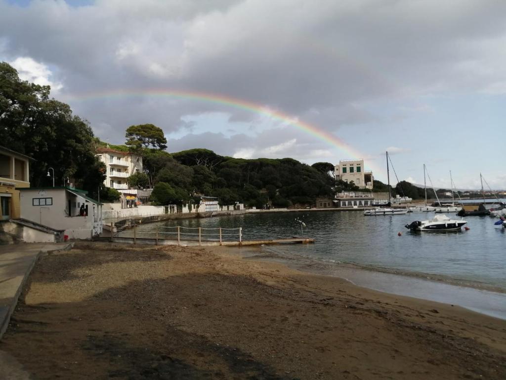 a rainbow over a body of water with a beach at Castiglioncello Suite in Castiglioncello