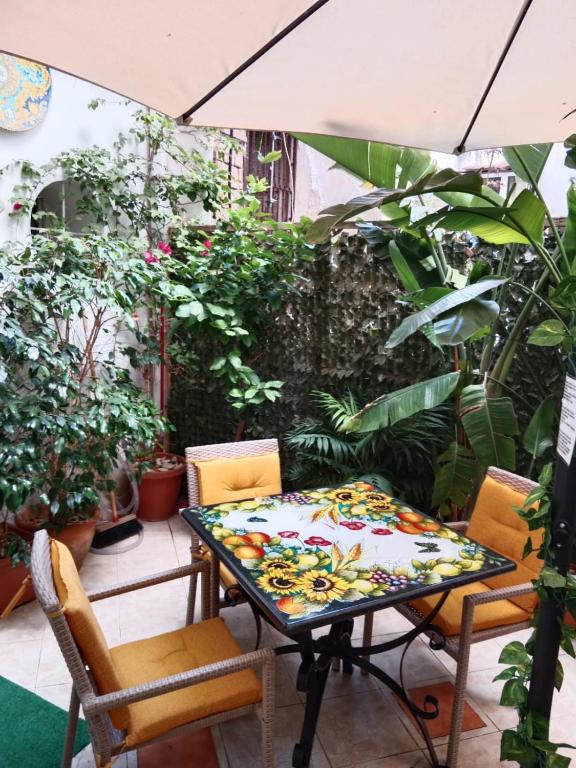 stół i krzesła na patio z roślinami w obiekcie Casa Sicana w mieście Palermo