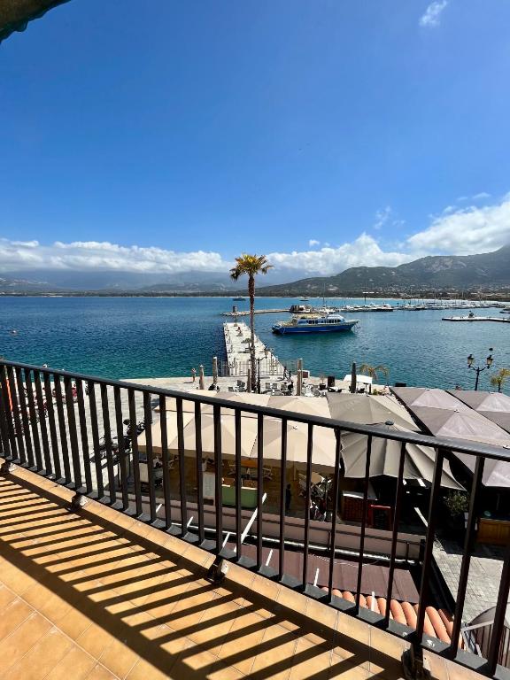 - un balcon avec vue sur l'eau et un bateau dans l'établissement Appartement de standing au port climatisé, centre-ville, proche plage et commerces, à Calvi