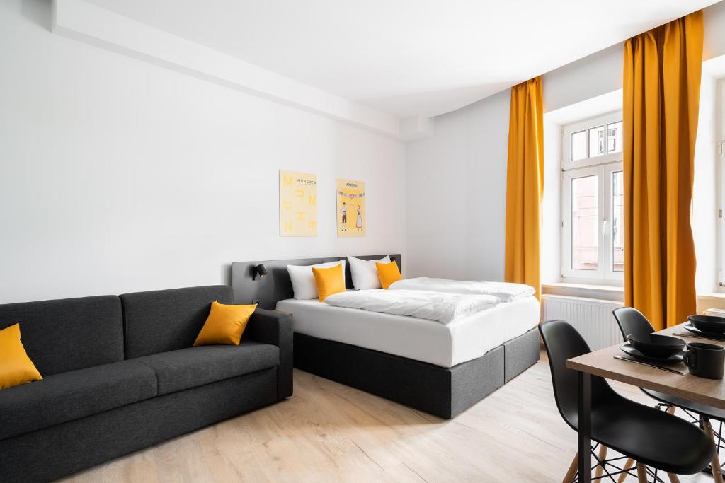 a living room with a bed and a couch at Servus Apartments by Homaris in Munich