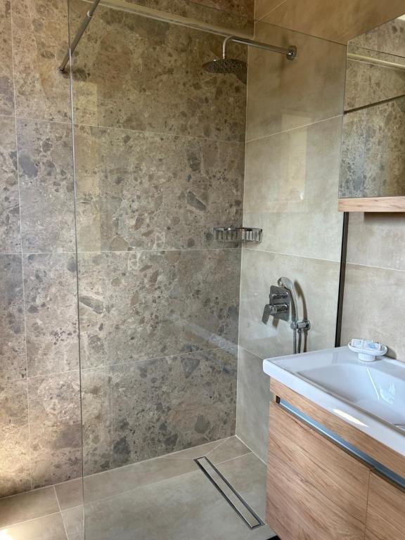 a bathroom with a shower and a sink at Georges Estates Hotel in Stoupa