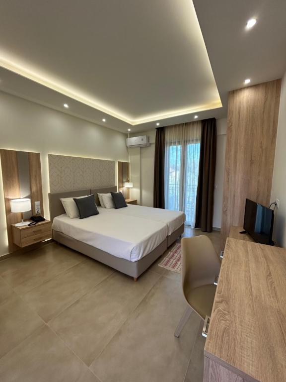 a hotel room with a bed and a television at Georges Estates Hotel in Stoupa