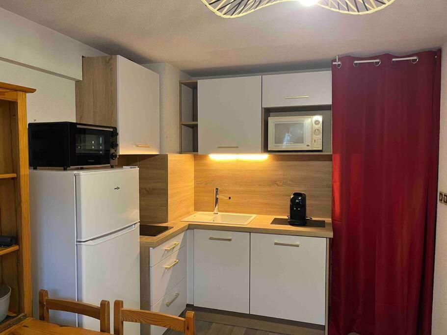 a kitchen with a white refrigerator and a microwave at Studio à Praz-sur-Arly in Praz-sur-Arly