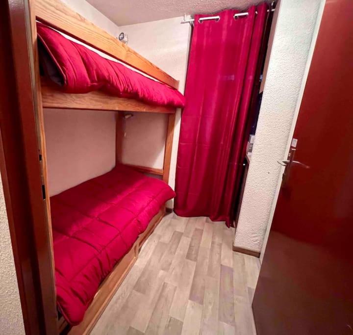 a room with two bunk beds with a red curtain at Studio à Praz-sur-Arly in Praz-sur-Arly