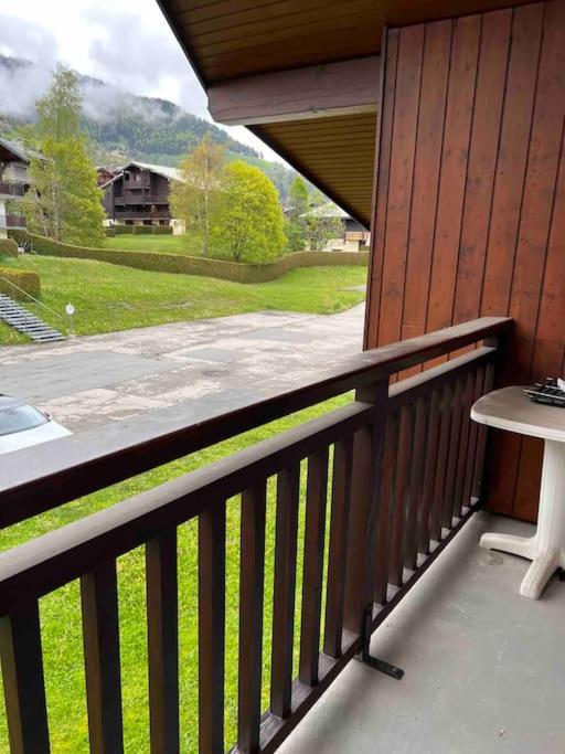a balcony with a table and a view of a yard at Studio à Praz-sur-Arly in Praz-sur-Arly
