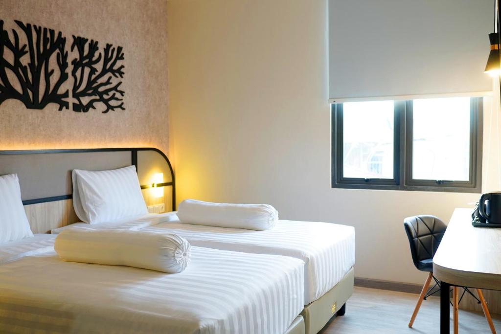 Postel nebo postele na pokoji v ubytování Front One Gosyen Hotel Salatiga
