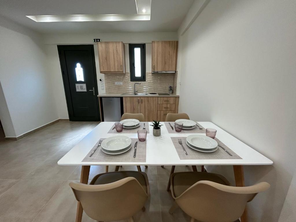 a white table and chairs in a room at Georges Estates Hotel in Stoupa