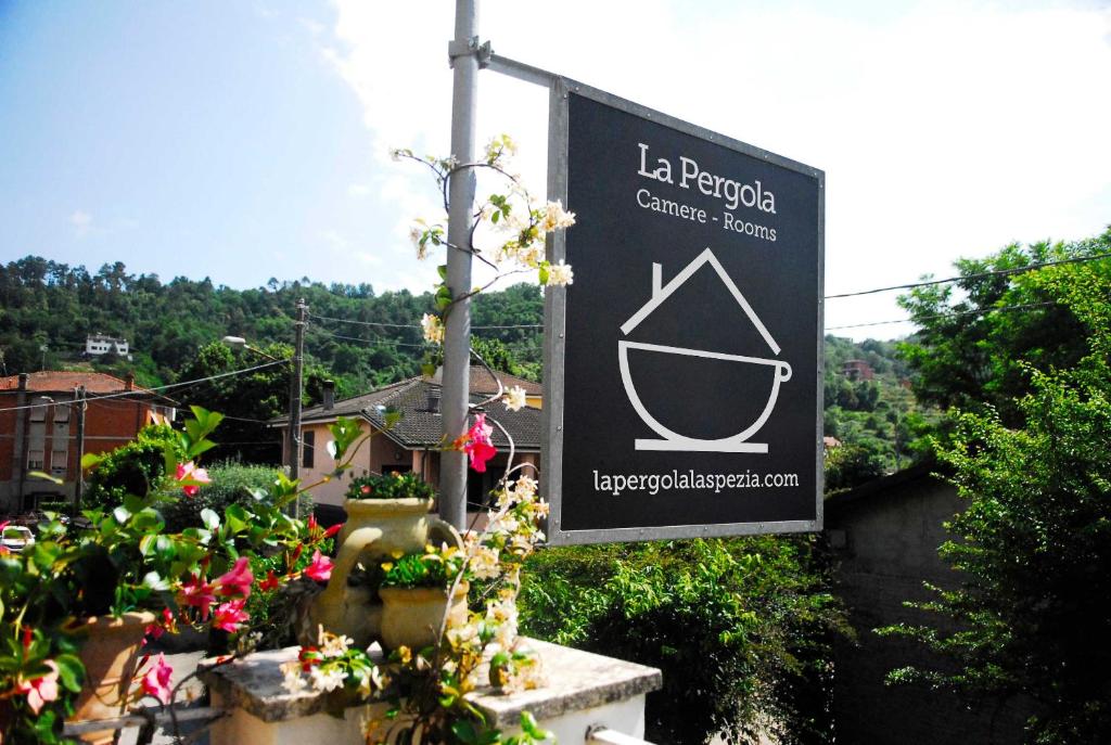 una señal para el centro de ciencias culturales de la pazoba con flores en La Pergola, en Vezzano Ligure