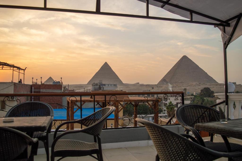 una vista sulle piramidi dal balcone di un ristorante di Pyramids Gate Hotel a Il Cairo