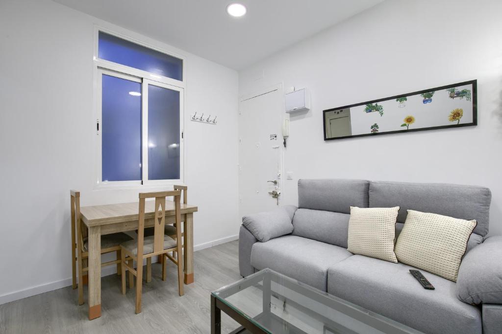 salon z kanapą i stołem w obiekcie Atocha Station - Apartamento de 2 dormitorios w Madrycie
