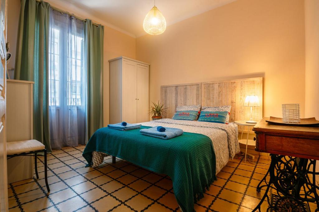 sypialnia z łóżkiem z zielonym kocem w obiekcie 2 bedrooms Apt, 10 mins to SAGRADA FAMILIA w Barcelonie