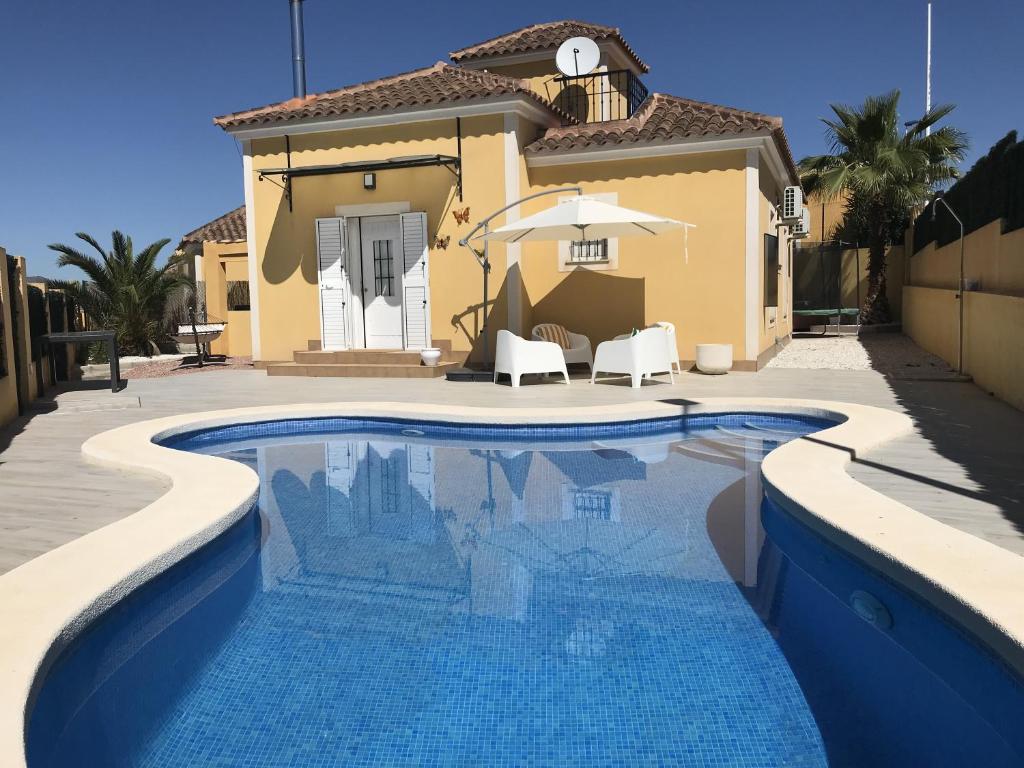 a swimming pool in front of a house at Villa Estrella with private pool in Mazarrón