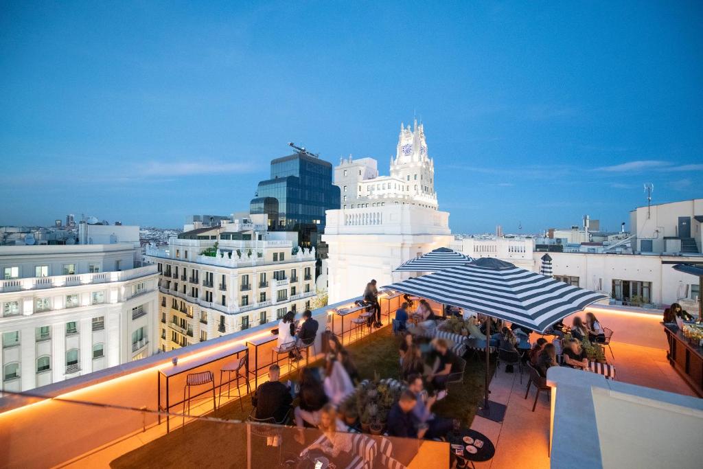a group of people standing on a balcony with an umbrella at Pestana CR7 Gran Vía Madrid in Madrid