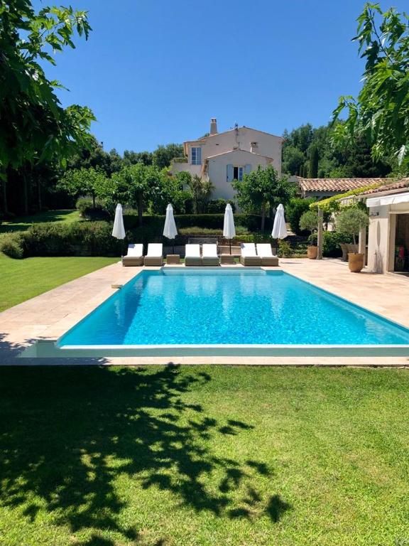 une piscine dans une cour avec des chaises et une maison dans l'établissement Villa Milefleure, à Grimaud