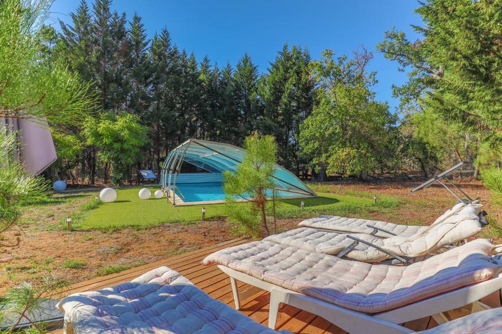eine Terrasse mit 2 Sofas und einem Zelt in der Unterkunft Domaine les Maisons des Houssats in Trensacq