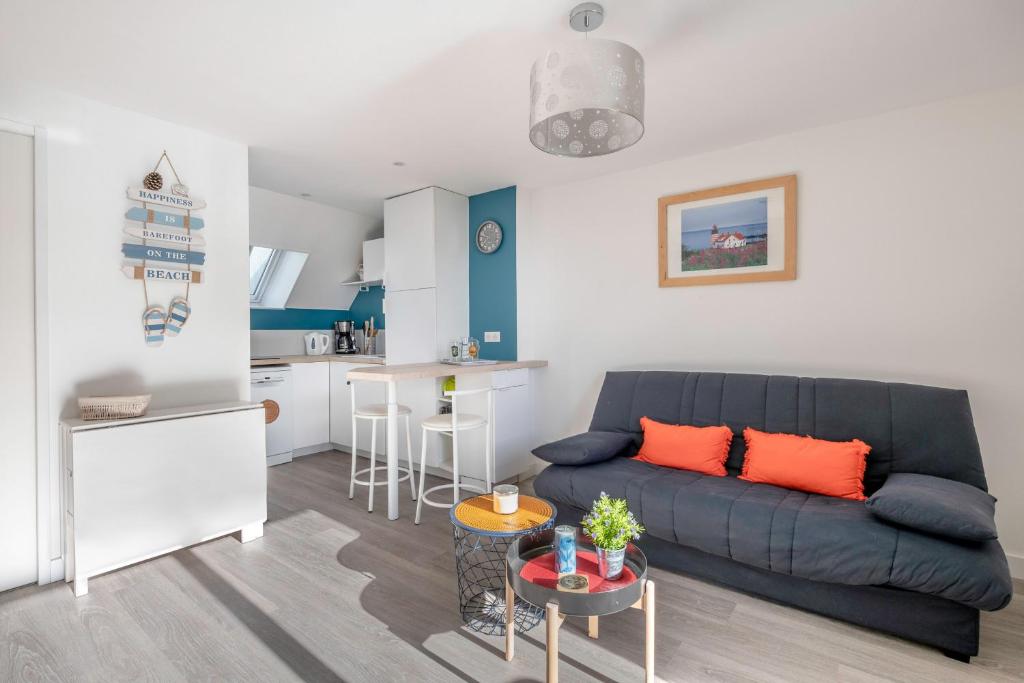a living room with a couch and a kitchen at Appartement vue mer et les pieds dans l'eau! in Saint-Sébastien