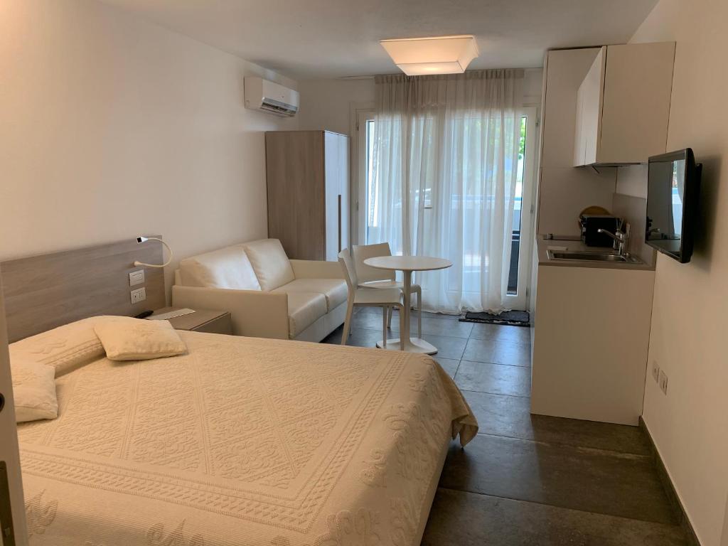 a hotel room with a bed and a living room at AppartArbus white suite in Arbus