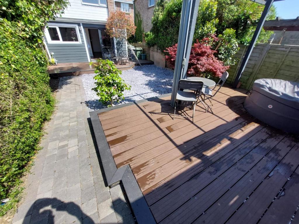 a backyard deck with a chair and a table at Perfect Cowes retreat with Hot Tub in Cowes