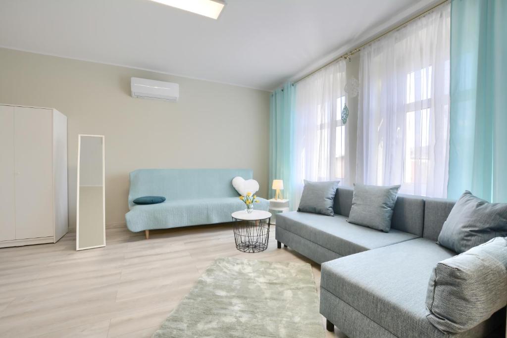 - un salon avec un canapé bleu et une chaise dans l'établissement Apartament w Górach Wałbrzyskich, à Boguszów-Gorce