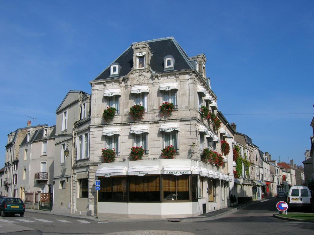 un gran edificio blanco con cajas de flores. en Hôtel Restaurant Des Remparts, en Chaumont