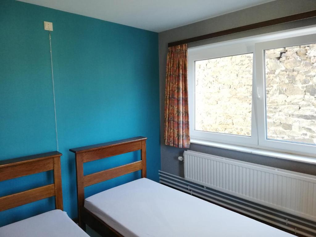 a bedroom with two beds and a window at Centre Louis Delobbe in Olloy-sur-Viroin