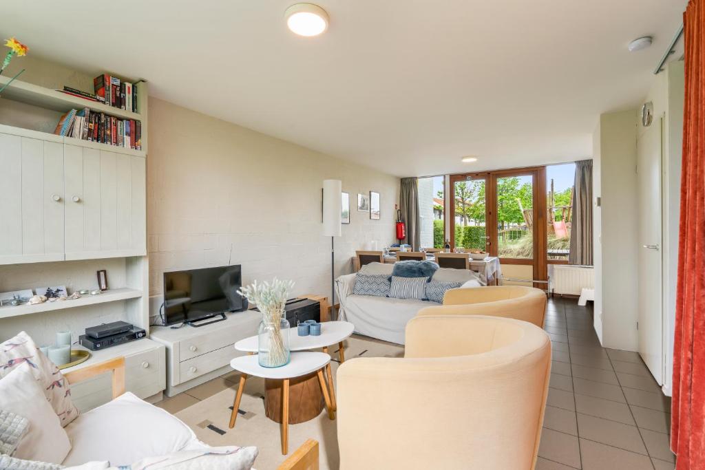 ein Wohnzimmer mit einem Sofa und einem TV in der Unterkunft Zeeanemoon - Holiday home for 6 persons in Middelkerke