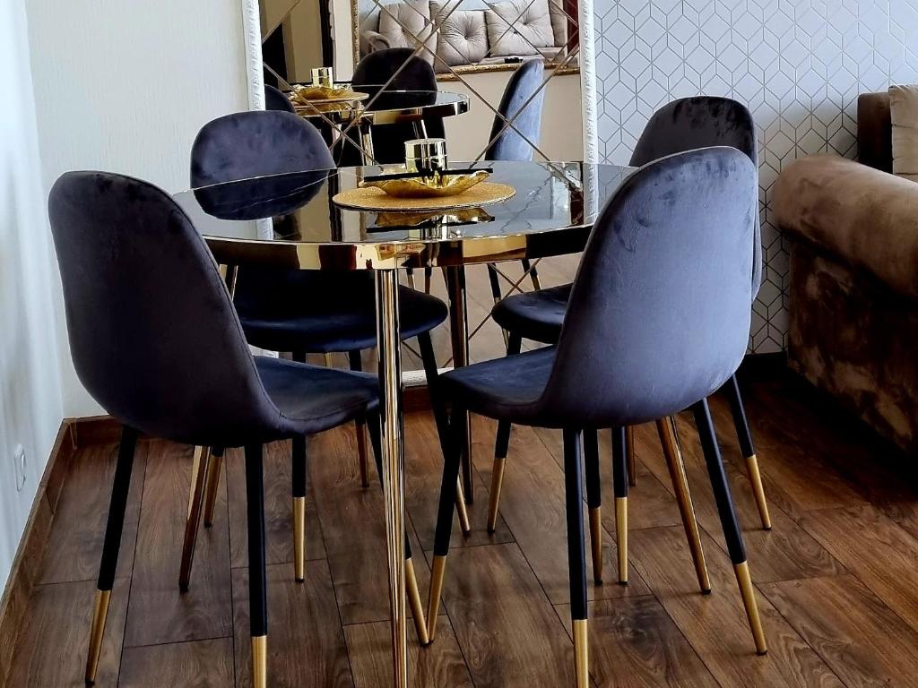 a dining room table with four chairs around it at JAG apartamentai miesto centre in Šiauliai