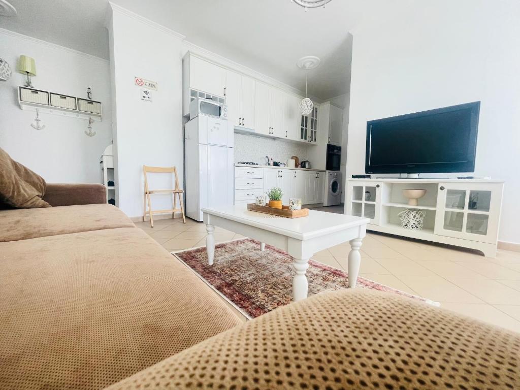 a living room with a couch and a table and a tv at Mediterranean Sea Apartments in Durrës