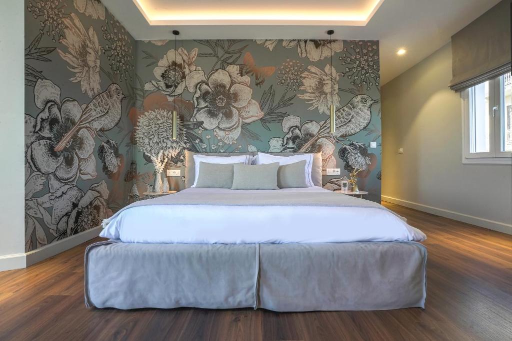 a bedroom with a large bed with a floral wallpaper at Pafsilipon Suites in Ermoupoli
