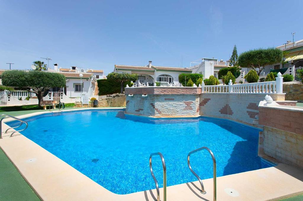 a large blue swimming pool in front of a house at CH Buganvillas Ciudad Quesada in Ciudad Quesada