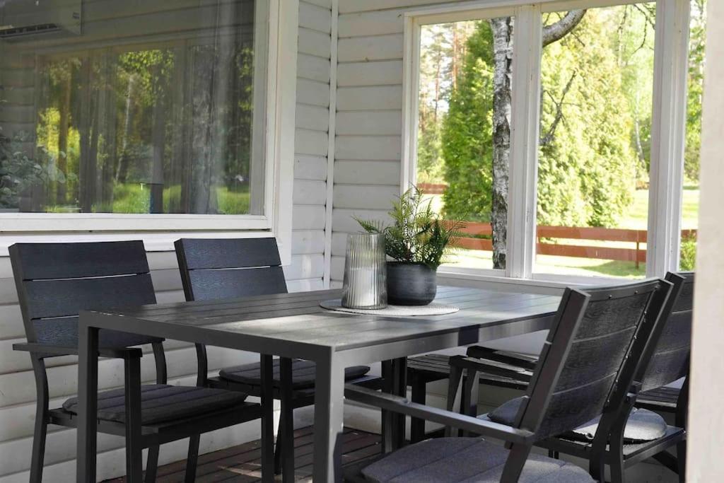 - une table et des chaises en bois sur une terrasse couverte avec moustiquaire dans l'établissement Stuga i vassemåla, à Vimmerby