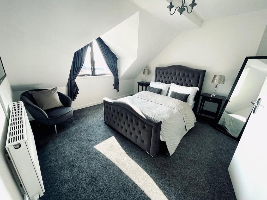 1 dormitorio con cama, silla y espejo en Baltic Dockside Apartment, Free Parking, en Liverpool