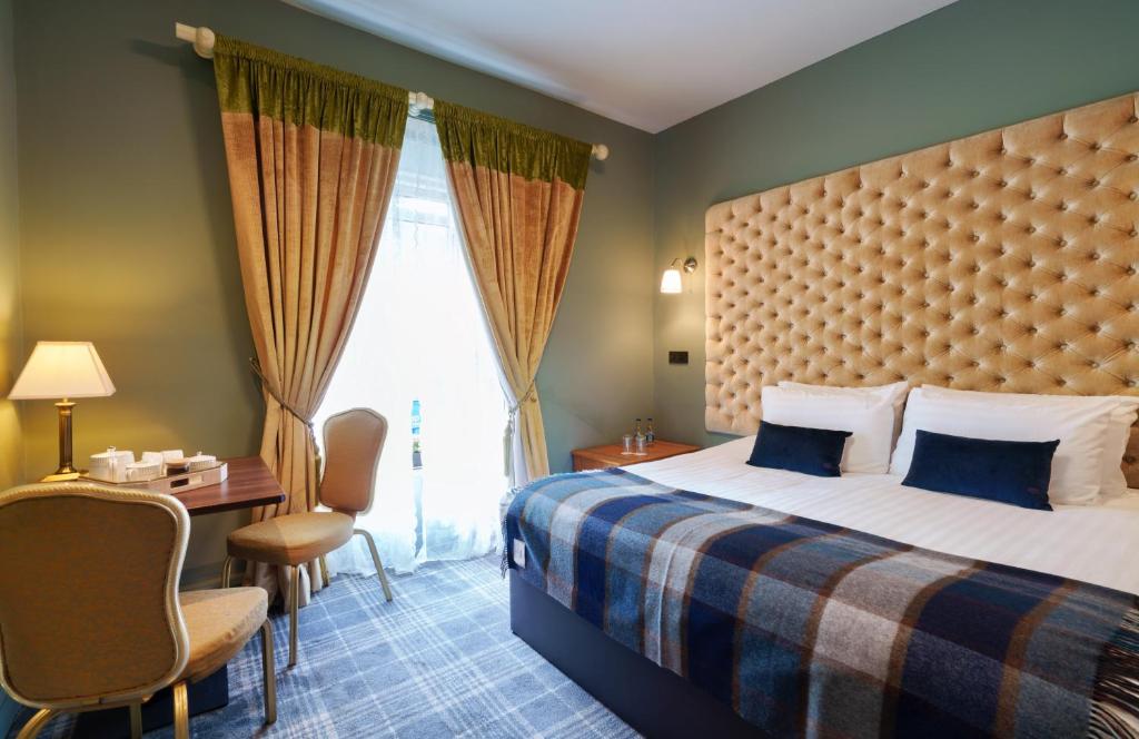 キャリック・オン・シャノンにあるTopper's Rooms Guest Accommodationのベッドとデスクが備わるホテルルームです。