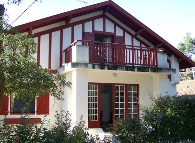 Maison blanche et rouge avec balcon dans l'établissement Mazouna - Hossegor agréable villa des années 60 rénovée sur terrain clos et arboré entre lac et océan, à Soorts-Hossegor