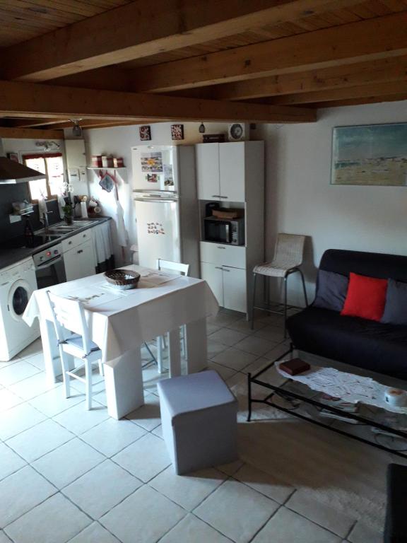 a kitchen and living room with a table and a couch at La P'tite Maison in Lisle