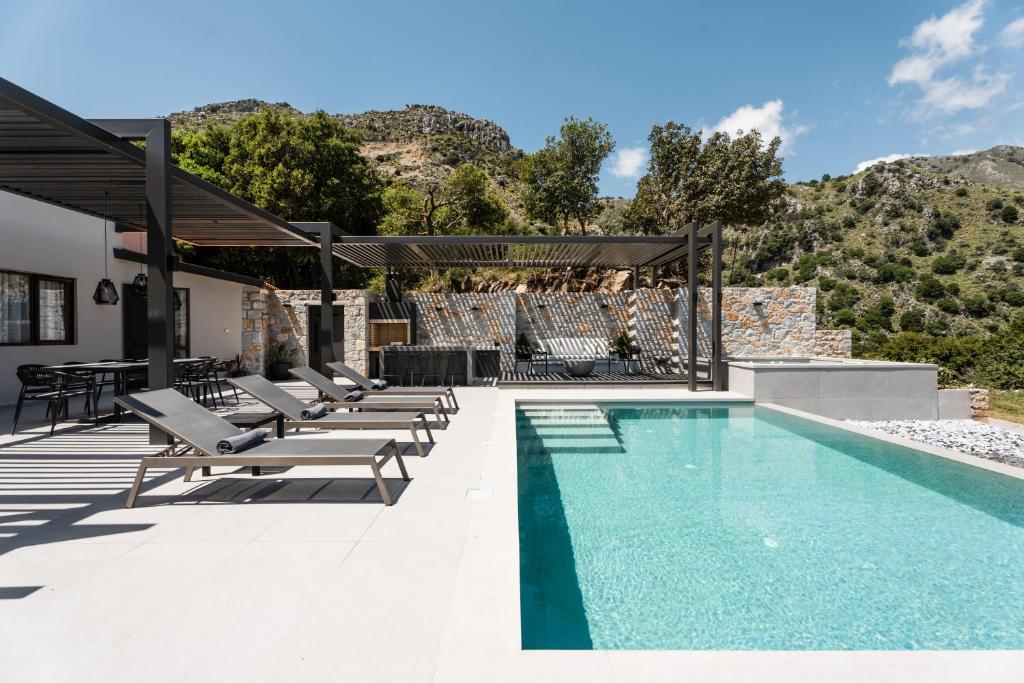 AsigoníaにあるEumelia Iconic Villa, with Heated Pool & Whirlpool, By ThinkVillaの家の隣に長椅子付きのスイミングプール