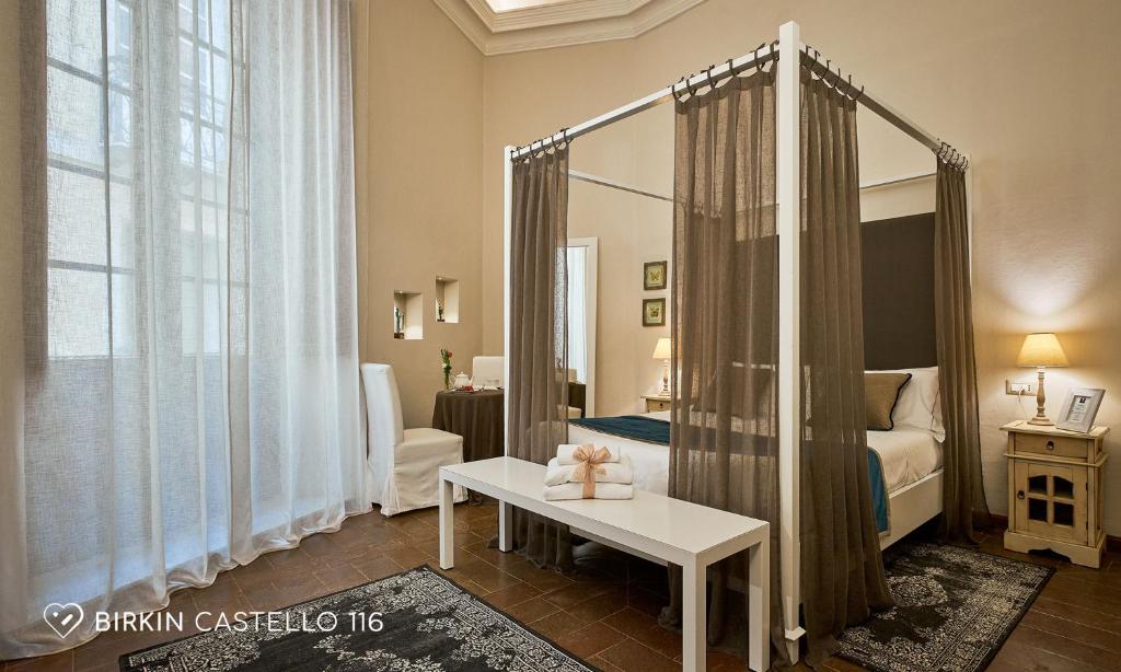 a bedroom with a mirror and a bed and a table at Albergo Diffuso Birkin Castello in Cagliari