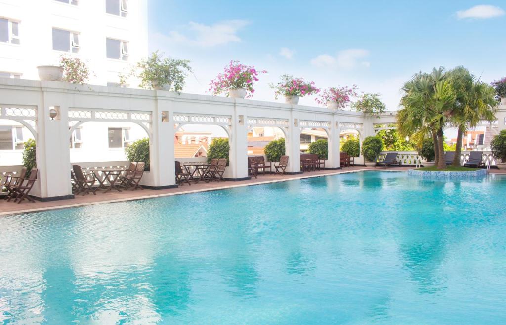 a swimming pool with blue water in a building at Pearl River Hotel in Hai Phong