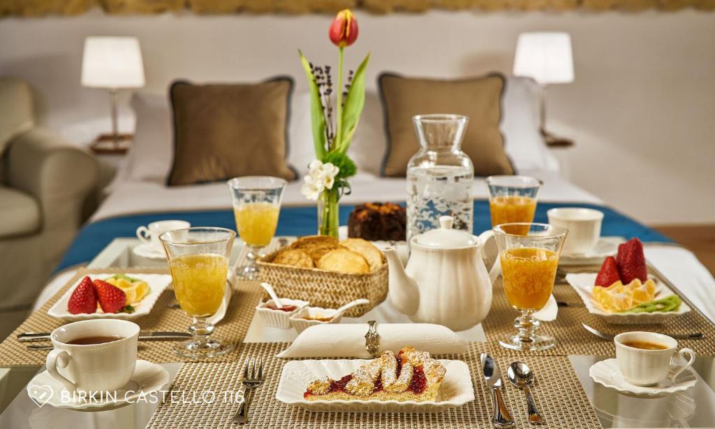 a breakfast table with food and drinks on a bed at Albergo Diffuso Birkin Castello in Cagliari