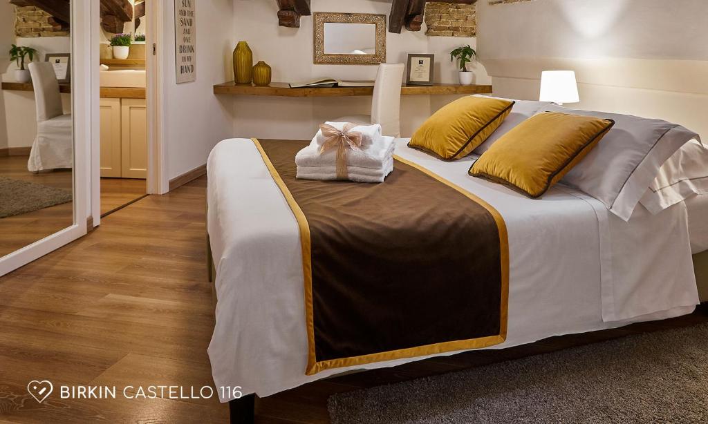 a bedroom with a large bed with yellow pillows at Albergo Diffuso Birkin Castello in Cagliari