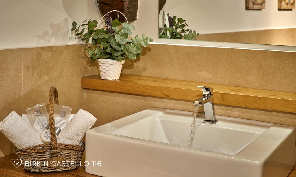 a sink with a faucet and a basket of plants at Albergo Diffuso Birkin Castello in Cagliari